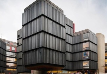 odkotva, fasáda přimomínající tmavé čedičové skály, pohled zepředu z boční ulice